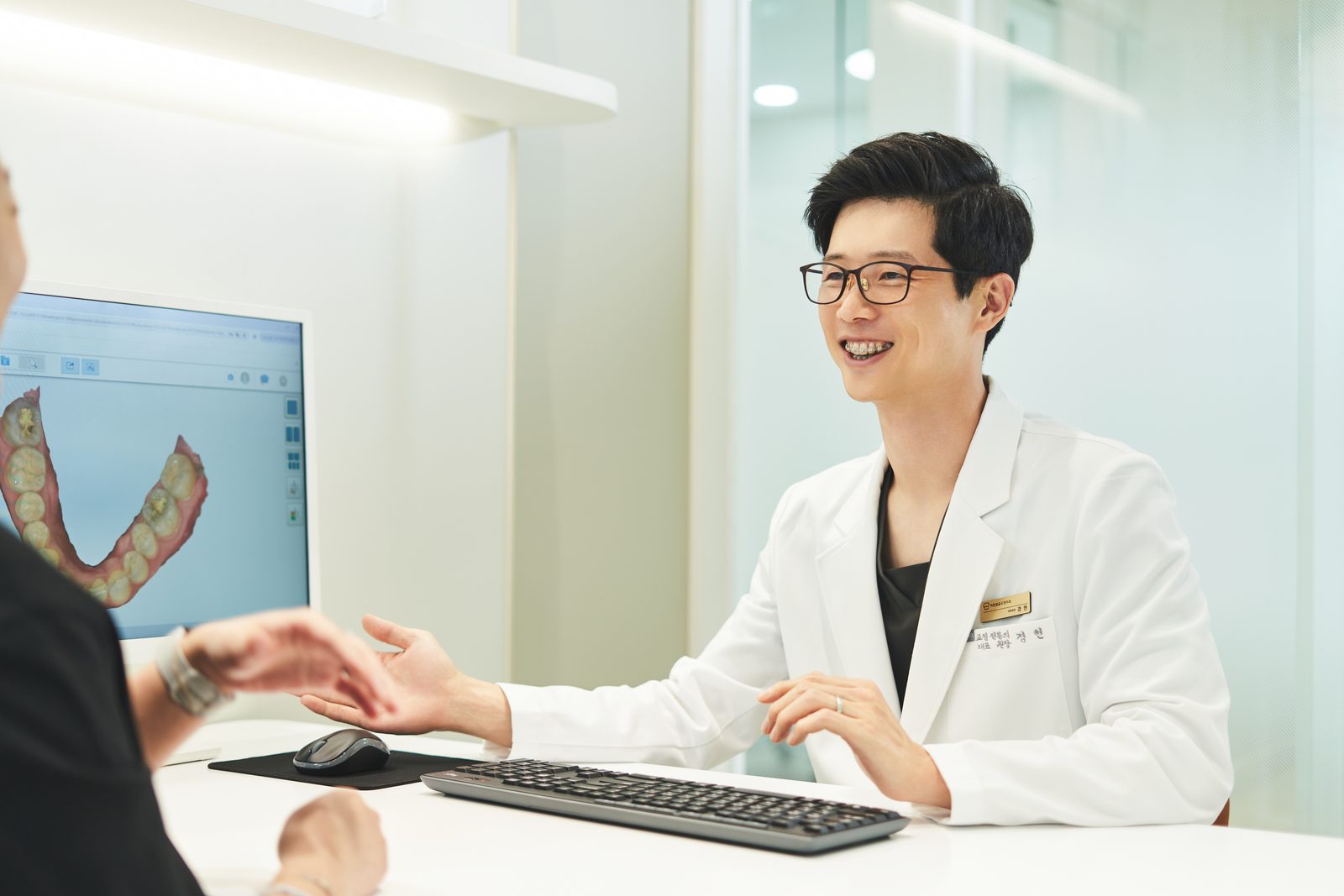 환자와 함께 3D 시뮬레이션 화면을 보는 교정 상담 장면
