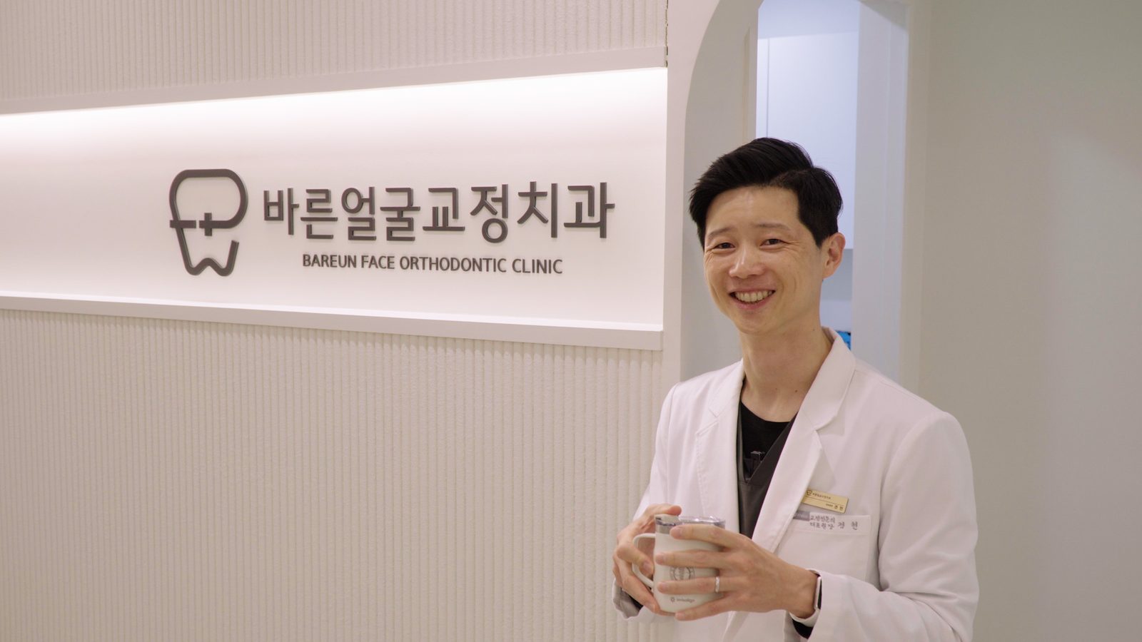 바른얼굴교정치과 로비 간판 앞의 대표원장 (유튜브 인터뷰)